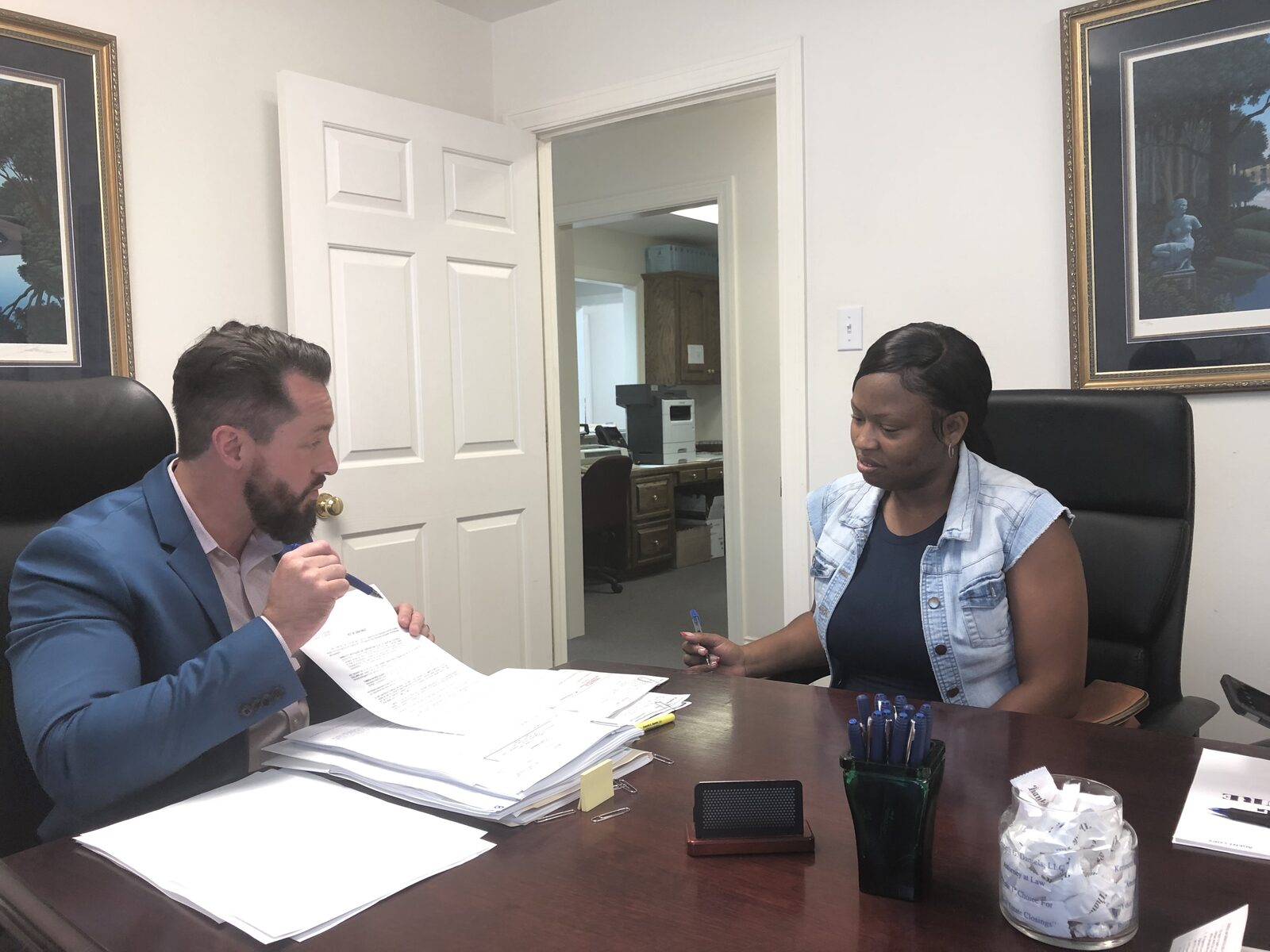 A homebuyer reviewing closing paperwork with a housing counselor across a desk